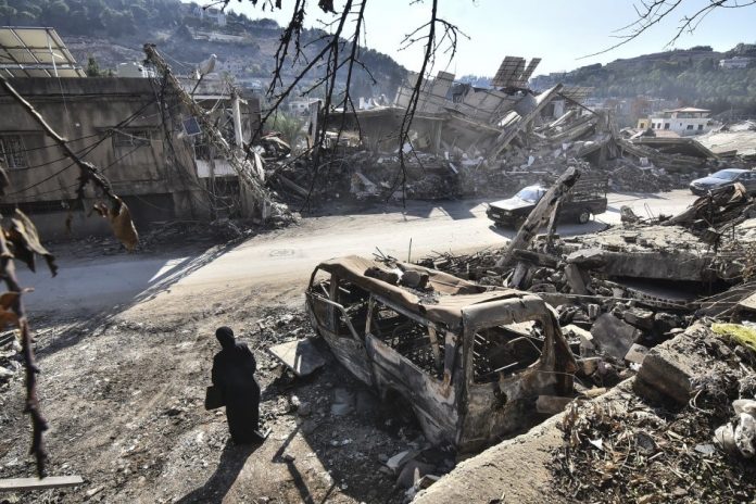 A returning resident to Nabatieh, in southern Lebanon, stands before the wreckage in the city on November 30, 2024, days after the start of a ceasefire between Israel and Hezbollah. © 2024 Fadel Itani/NurPhoto via AP